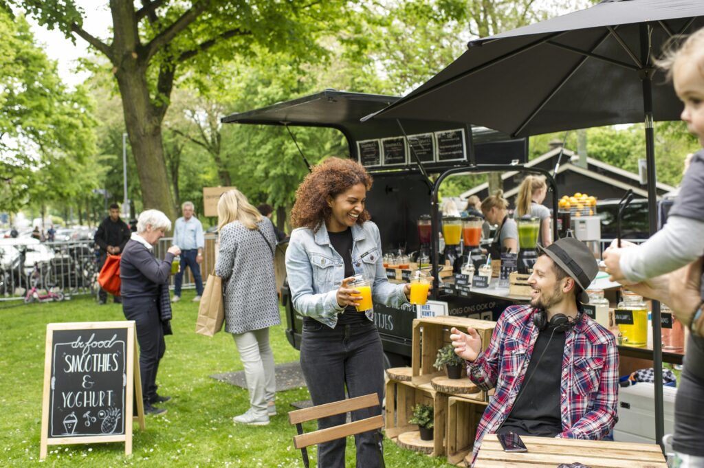 Markt met foodtruck en inwoners die gezellig aan een tafel zitten