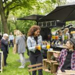 Markt met foodtruck en inwoners die gezellig aan een tafel zitten